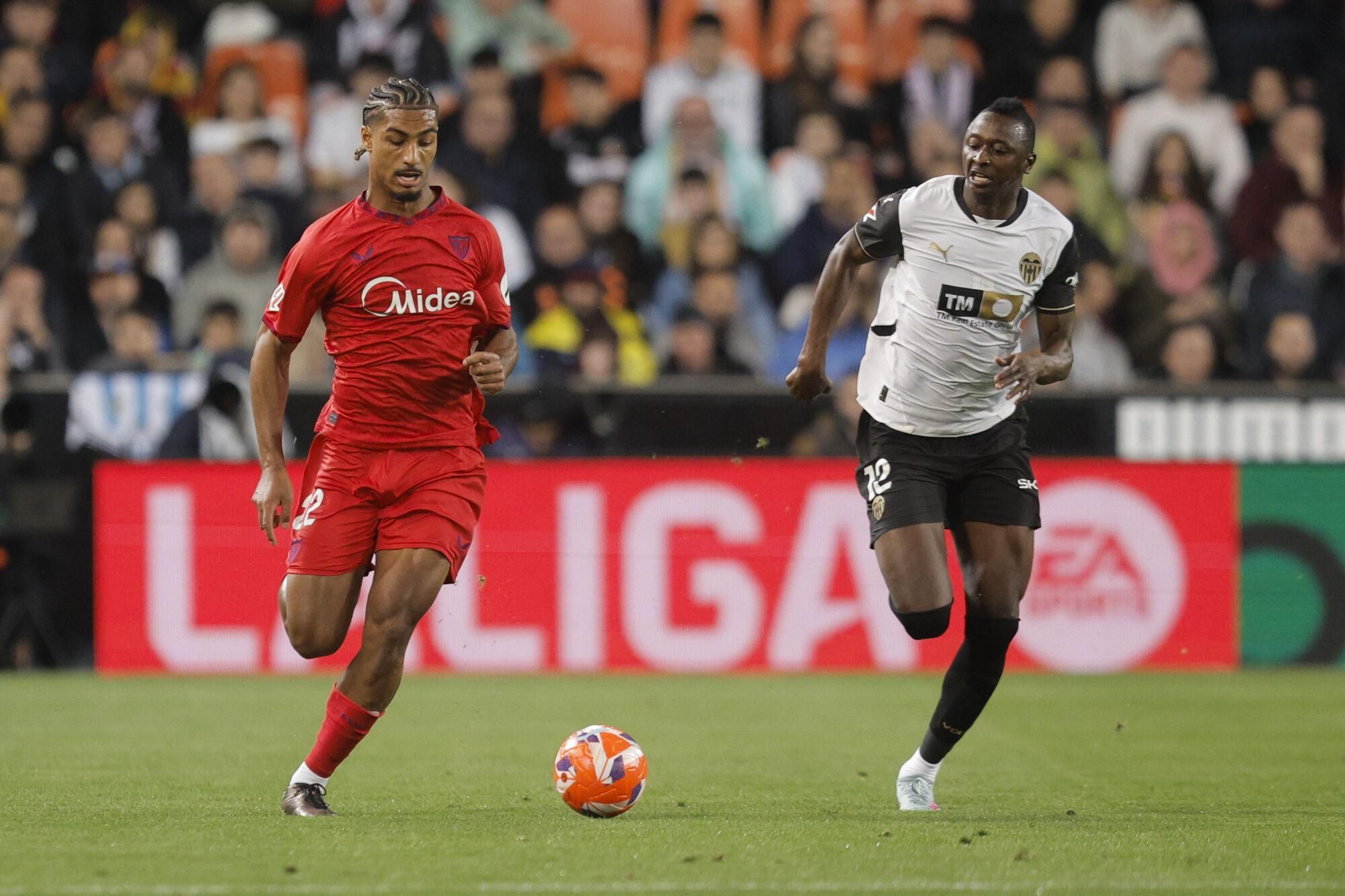 VALENCIA, 11/04/2025.- El delantero del Valencia Umar Sadiq (d) disputa el balón con el defensa del Sevilla Loic Badé (i) durante el partido de Liga disputado este viernes en el estadio de Mestalla. EFE/Kai Forsterling