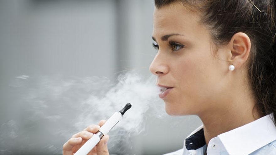 Una joven fuma con un cigarrillo electrónico.