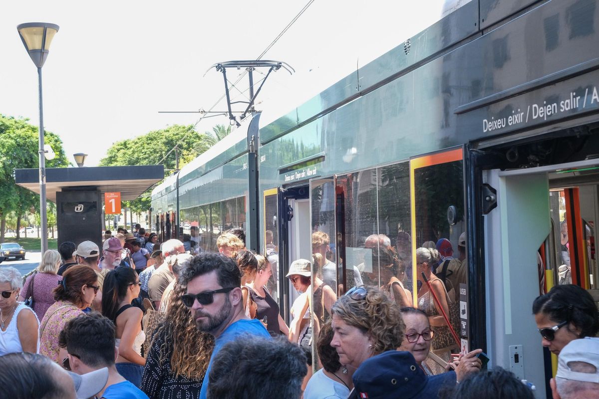 Numerosos pasajeros tratan de subir y bajar de un TRAM, en El Campello este lunes.