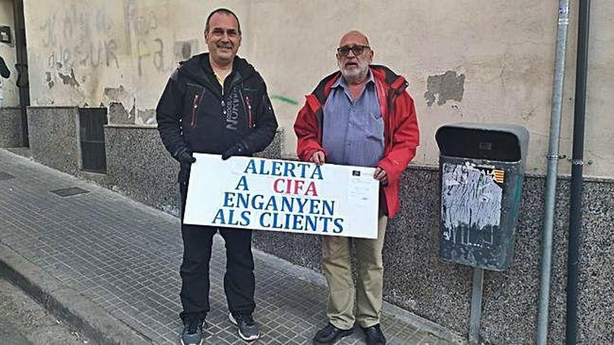 Els dos fills del matrimoni afectat, ahir, amb el cartell als voltants de la immobiliària