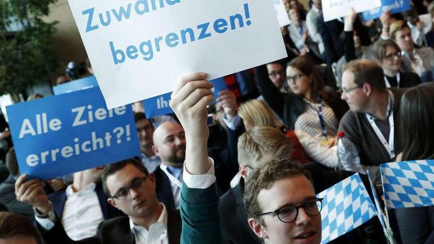 Jóvenes cristianodemócratas exhiben pancartas pidiendo la limitación de la emigración durante su congreso en Dresde, en el que intervino Angela Merkel.