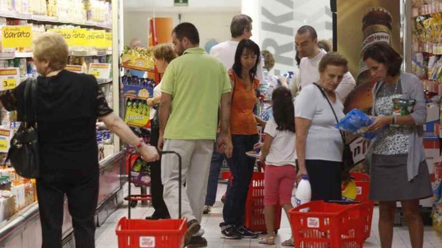 Varias personas hacen la compra en una gran superficie.