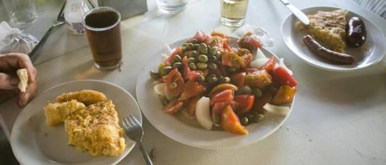 GRAN AMBIENTE A DIARIO en el Caribe.José María García, sirviendo una de las tapas». La terraza, animada cada mañana.El bar Caribe se encuentra en la vieja N-340, hoy denominada avenida Castell Vell. Los socios y los trabajadores &amp;mdash;prácticamente una familia&amp;mdash;, junto al enorme surtido de manjares preparados para servir.