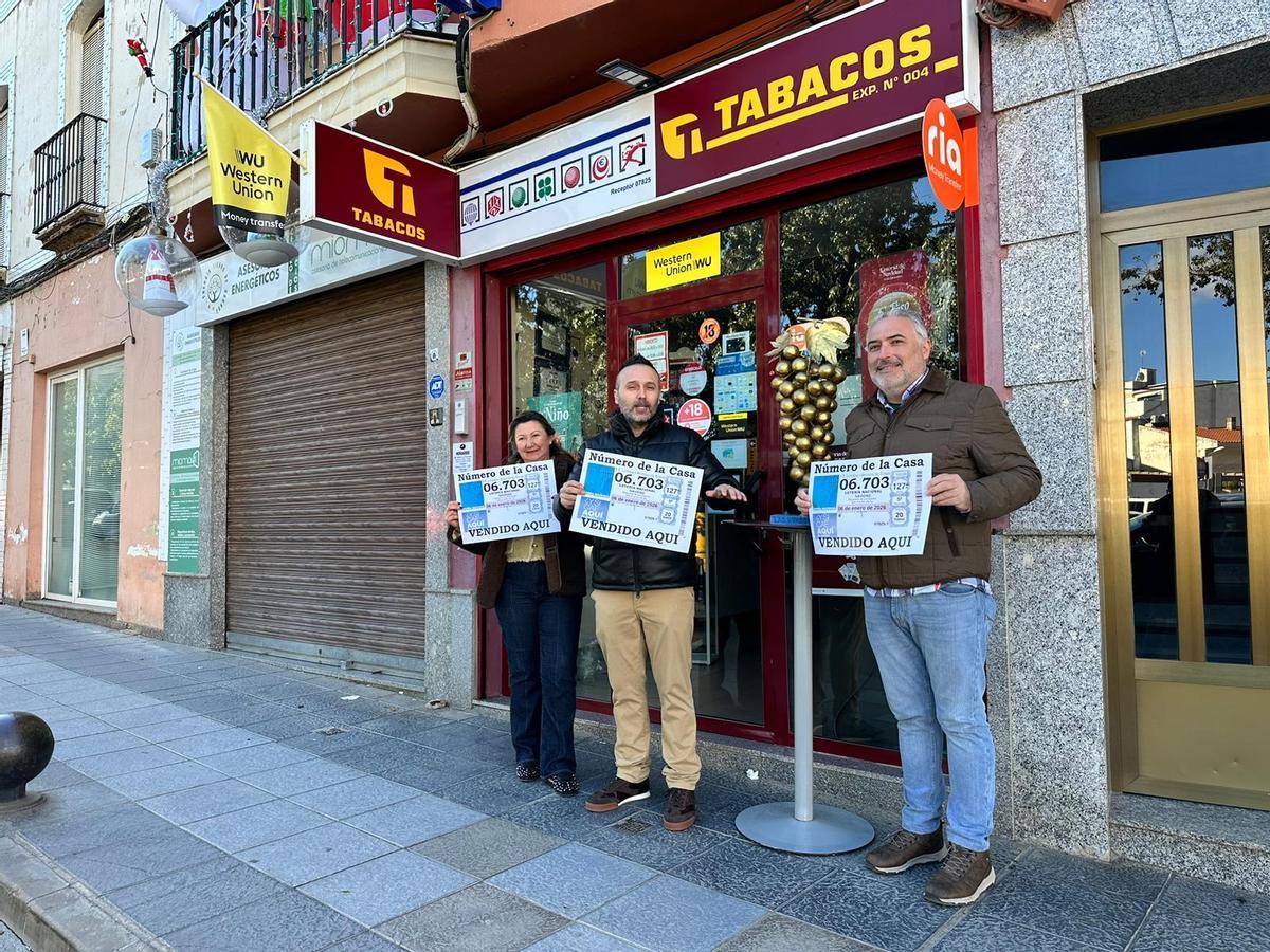 Los propietarios de la administración de lotería de Almendralejo junto a un vecino con el número premiado.