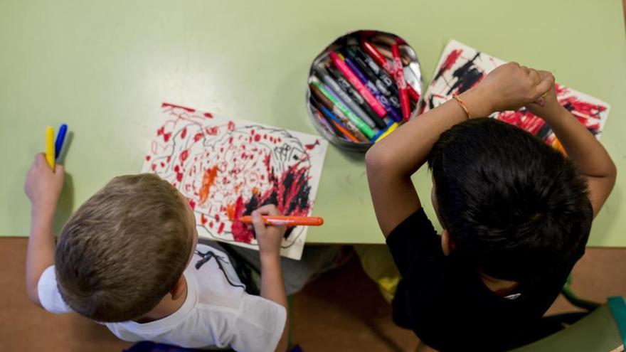 Dos pequeños pintan en el colegio.