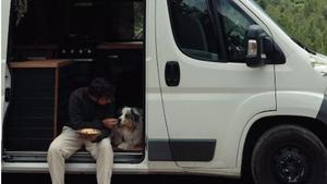 El influencer Juanma López comiendo junto a su perro dentro de su camper.