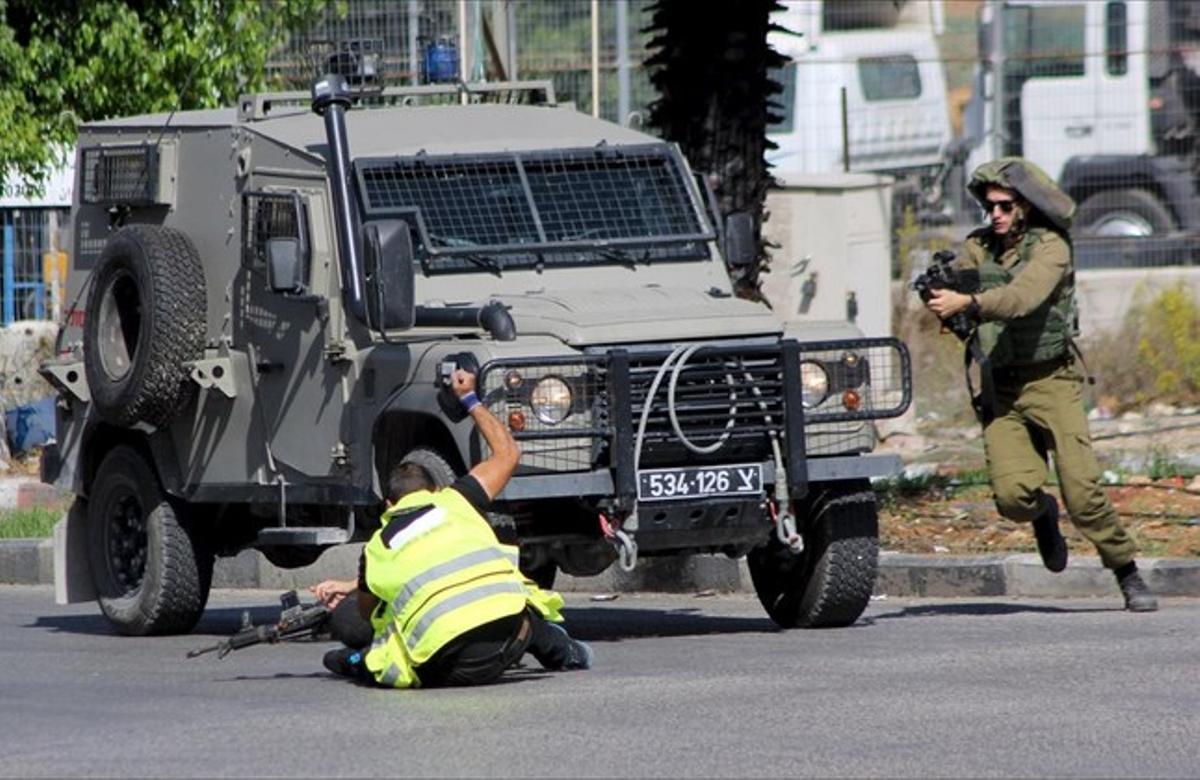 Un palestí, amb una armilla fluorescent i el distintiu de «premsa», apunyala a un soldat israelià a Hebron. Els soldats van matar després a l’agressor. Un palestí, amb una armilla fluorescent i el distintiu de «premsa», apunyala a un soldat israelià a Hebron. Els soldats van matar després a l’agressor.