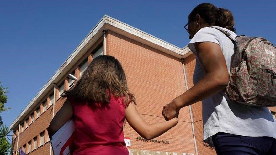 Una madre acompaña a su hija al colegio.