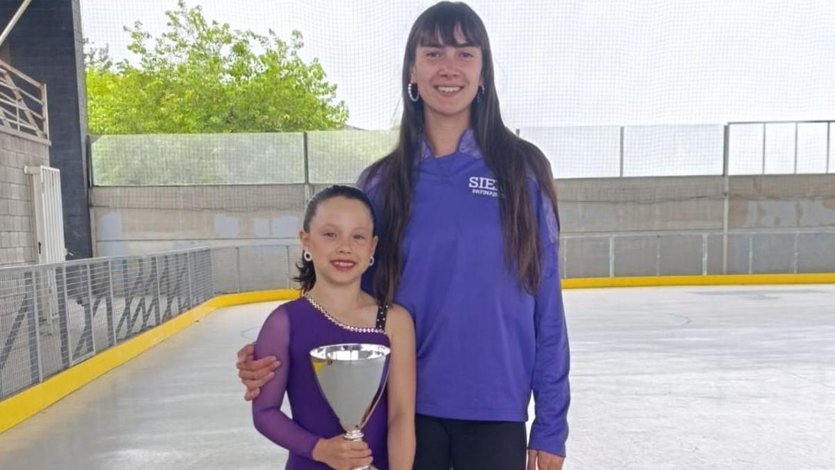 Erica Cortina, con su entrenadora Paola García, y el trofeo como campeona de Asturias.