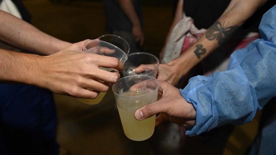 Un grupo de jóvenes realiza un botellón en la calle.