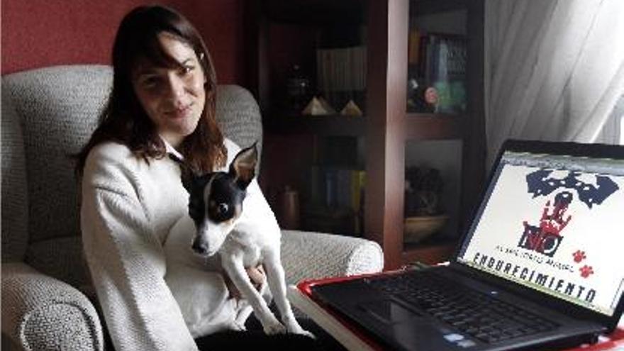 Laura Tomás, en su casa de Valencia con uno de sus perros que rescató de la perrera.