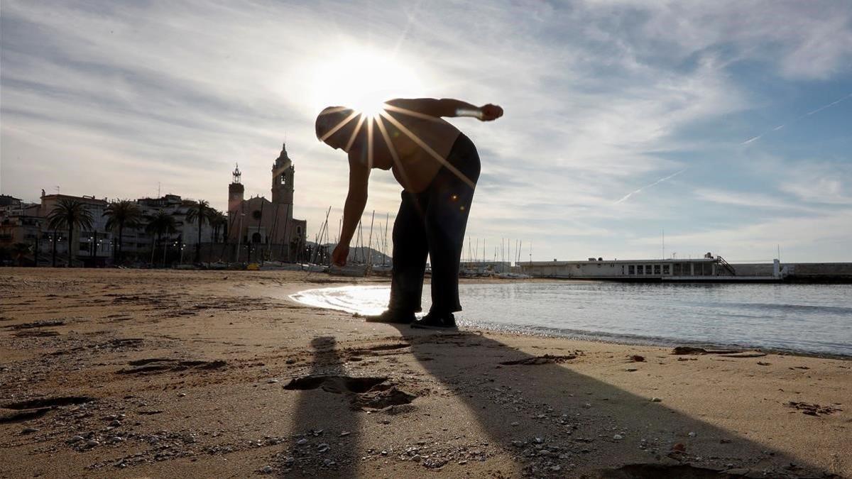 Un hombre hace ejercicio en la playa de Sitges