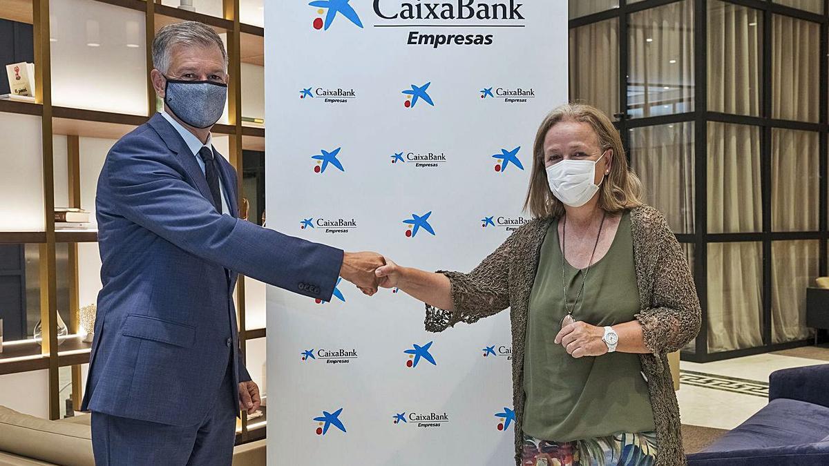 El director territorial de CaixaBank, Xicu Costa, entrega el galardón a Araceli Císcar. | LEVANTE-EMV