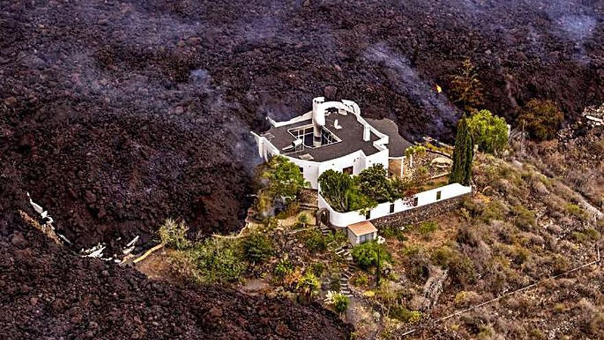 Imagen tomada desde un helicóptero por las coladas engullendo varias viviendas en La Palma. 