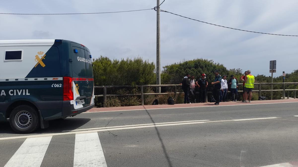 Los agentes custodian a los migrantes en la carretera. Carmelo Convalia