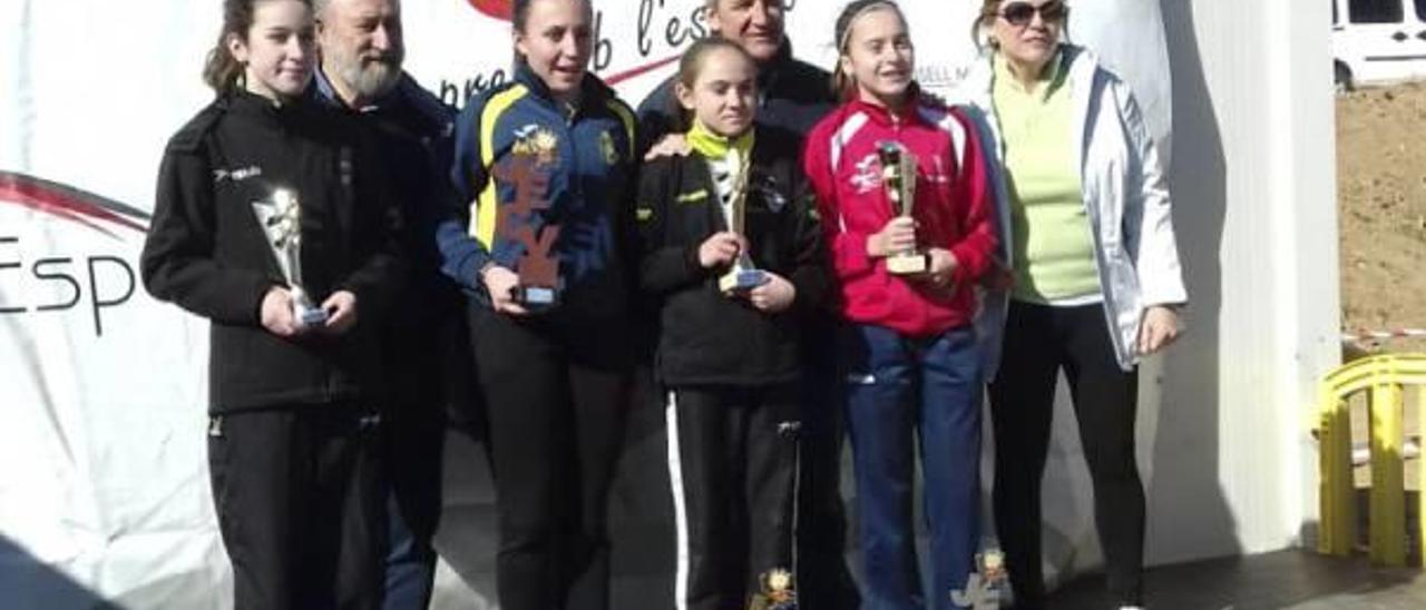 Una atleta del CAX, a la derecha, con el trofeo en el podio del Cross.