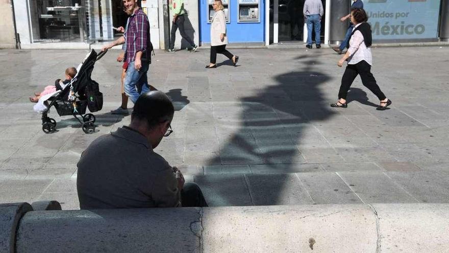 Un hombre se protege del sol con la sombra del Obelisco.