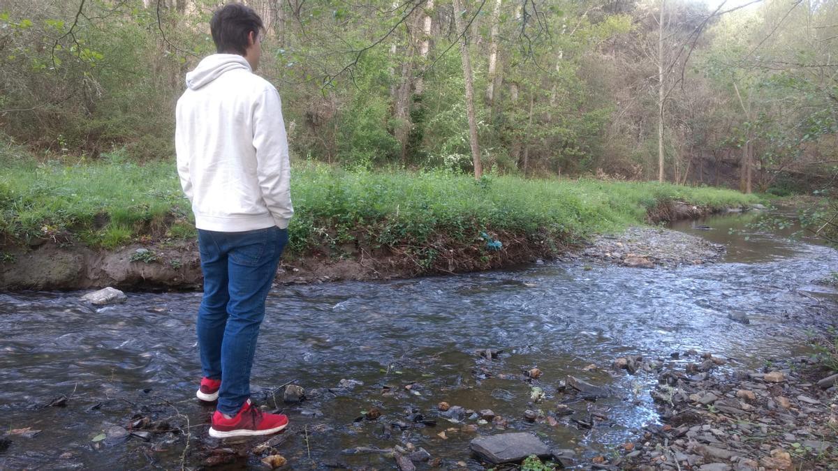 Un joven al lado del cauce del río Angueira