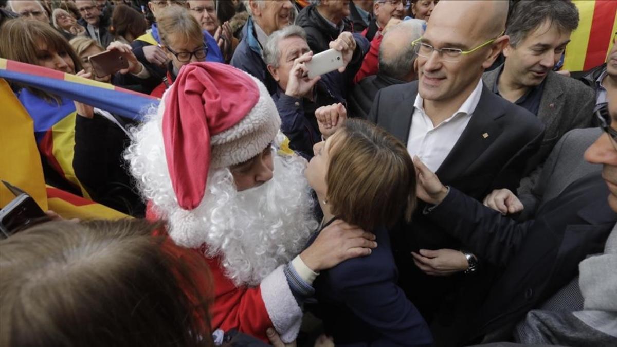 Un 'papá noel' saluda a Carme Forcadell a su salida del TSJC.