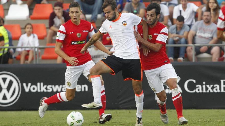 Pedro Inglés y Dalmau defiende a un jugador del Mestalla, en el duelo de la pasada campaña.