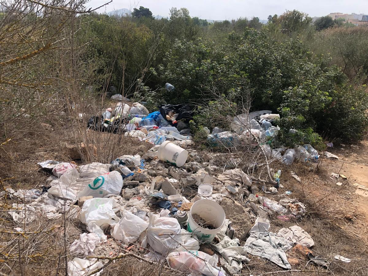 Restos de basura se acumulan en la vegetación.