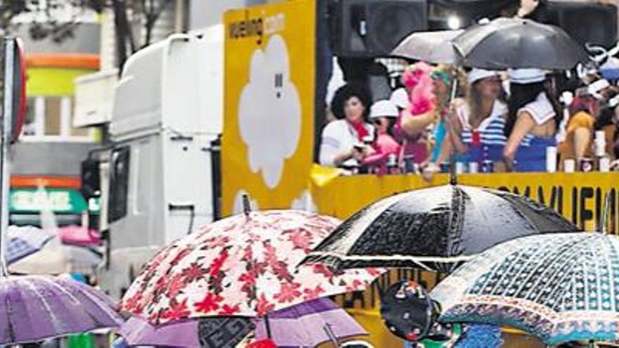 Ciudadanos con paraguas ven pasar una de las carrozas que participaron en la Cabalgata, el pasado sábado. i JC GUERRA