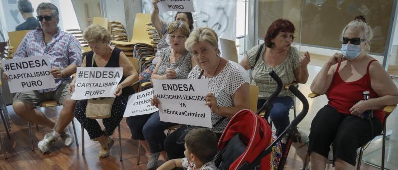 Varias vecinas muestran carteles reivindicativos en su encierro en el centro Cívico de la Plata.