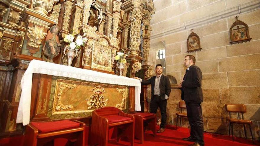 El párroco de Donramiro muestra a Carnero el retablo del templo, que podría ser restaurado.