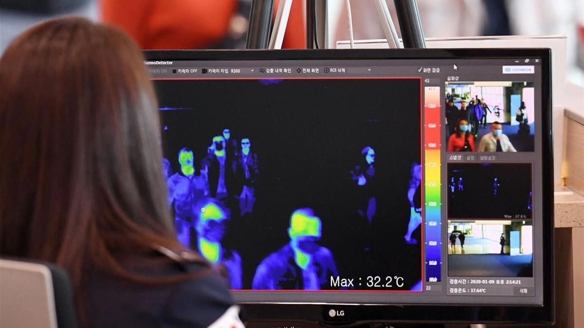 Una vigilante de seguridad de un aeropuerto de Corea del Sur mira por un monitor las imágenes de una cámara térmica para localizar posibles infectados del nuevo virus detectado en China.