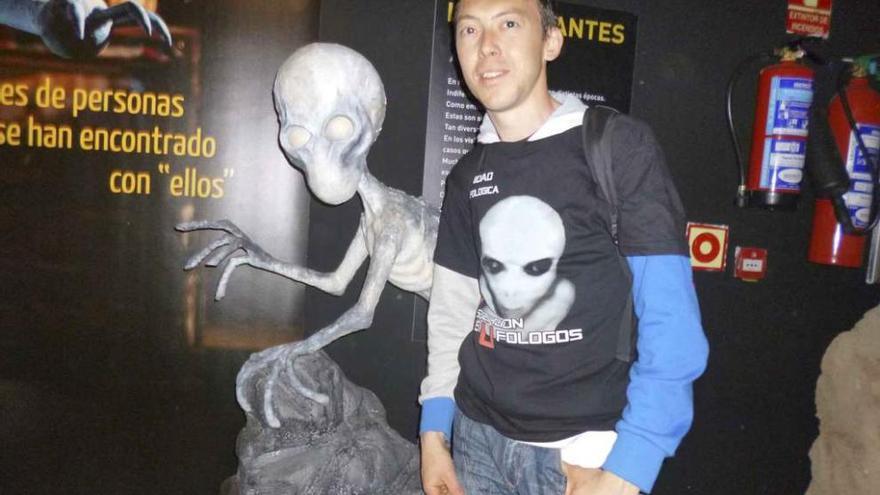 Fernando Domínguez, posa junto a una escultura de un extraterrestre en una exposición. Foto