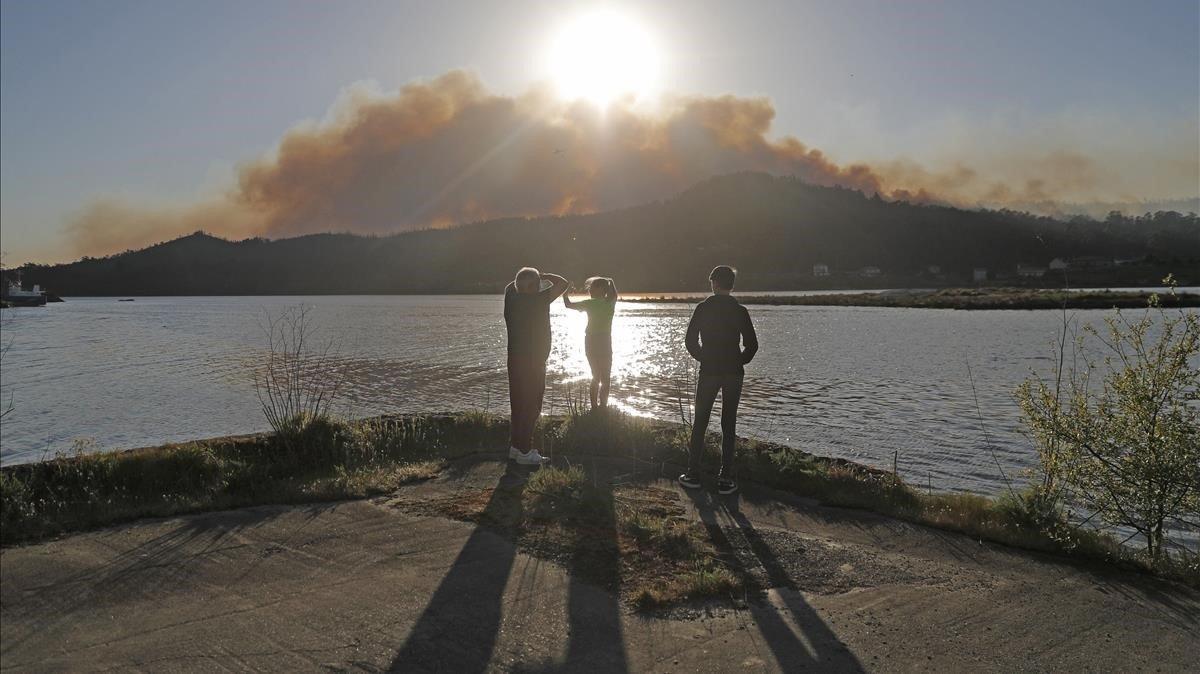 Vecinos de la localidad corunesa de Rianxo cerca de uno de los numerosos focos del incendio  en la Ria de Arosa