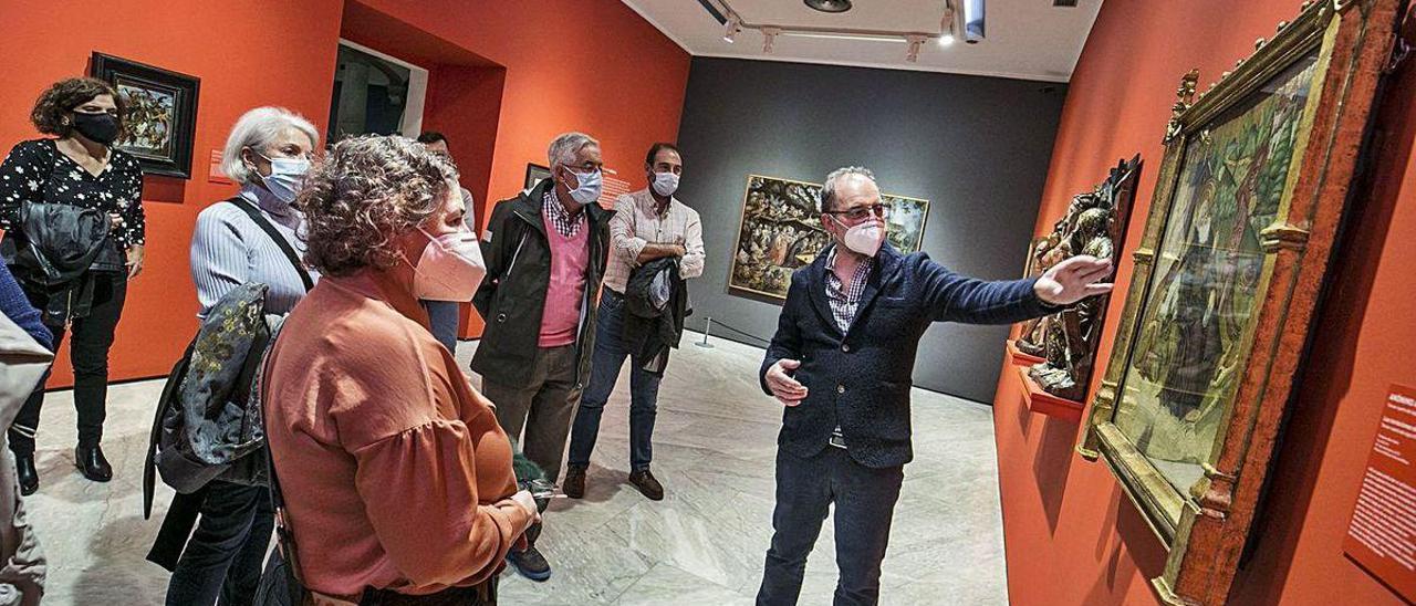 Gabino Busto comenta una de las obras de &quot;El diablo, tal vez&quot; durante la visita guiada a la exposición.