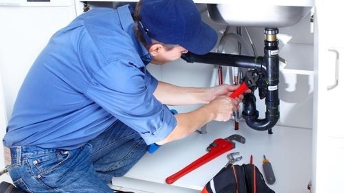 Un fontanero realiza una reparación.