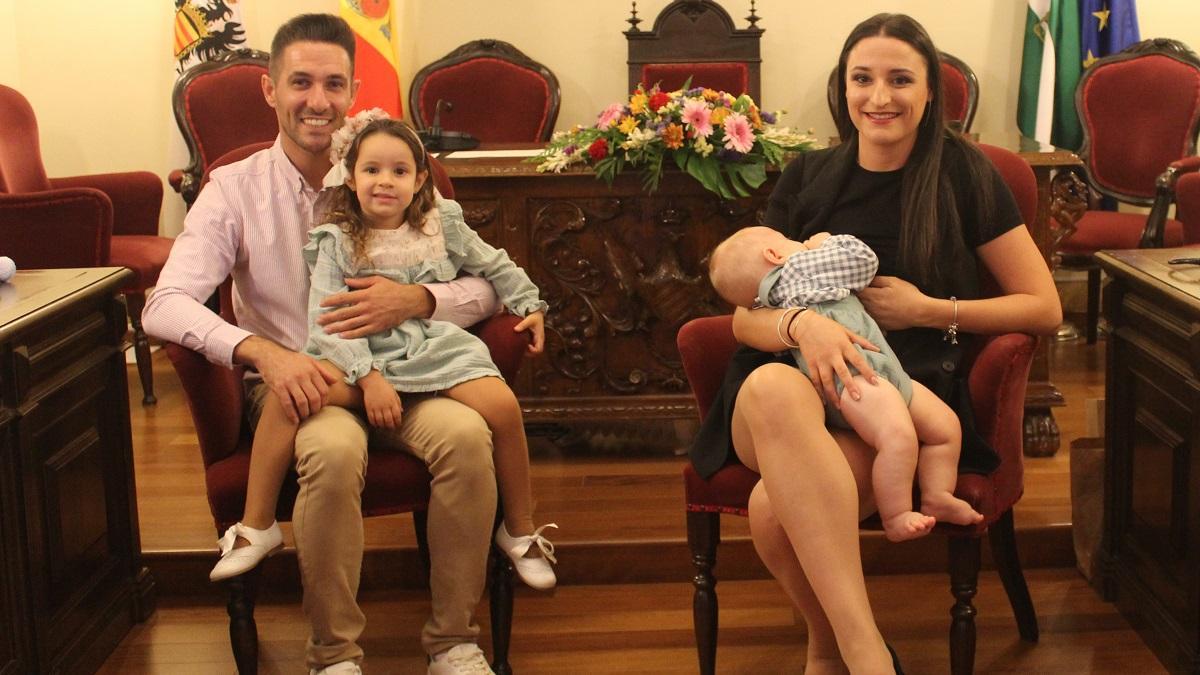 Los niños apadrinados por lo civil, con sus padres, en el salón de plenos del Ayuntamiento de Aguilar.