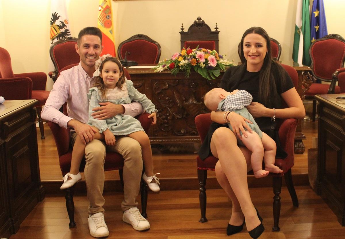 Los niños apadrinados por lo civil, con sus padres, en el salón de plenos del Ayuntamiento de Aguilar.