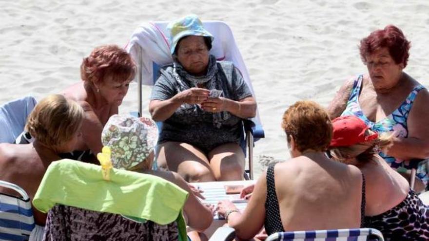 Un grupo de mujeres jubiladas jugando a las cartas en la playa de Benidorm.