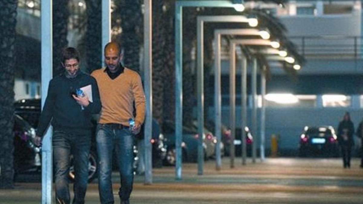 Pep Guardiola, junto a Sergi Nogueras, jefe de prensa, anoche en la ciudad deportiva del Barça.