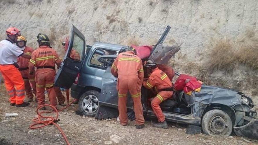 Los bomberos, ayer sobre el automóvil accidentado, durante las tareas de excarcelación.