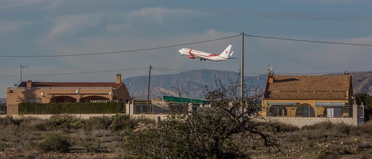 Dos viviendas de planta baja ubicadas en El Altet, muy próximas al aeropuerto de Alicante-Elche, durante la operación de despegue de una aeronave.