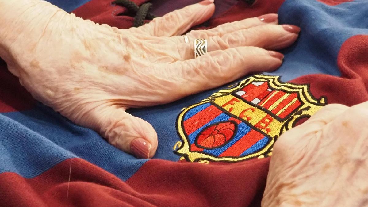 Una manos palpan una camiseta antigua del Barça.