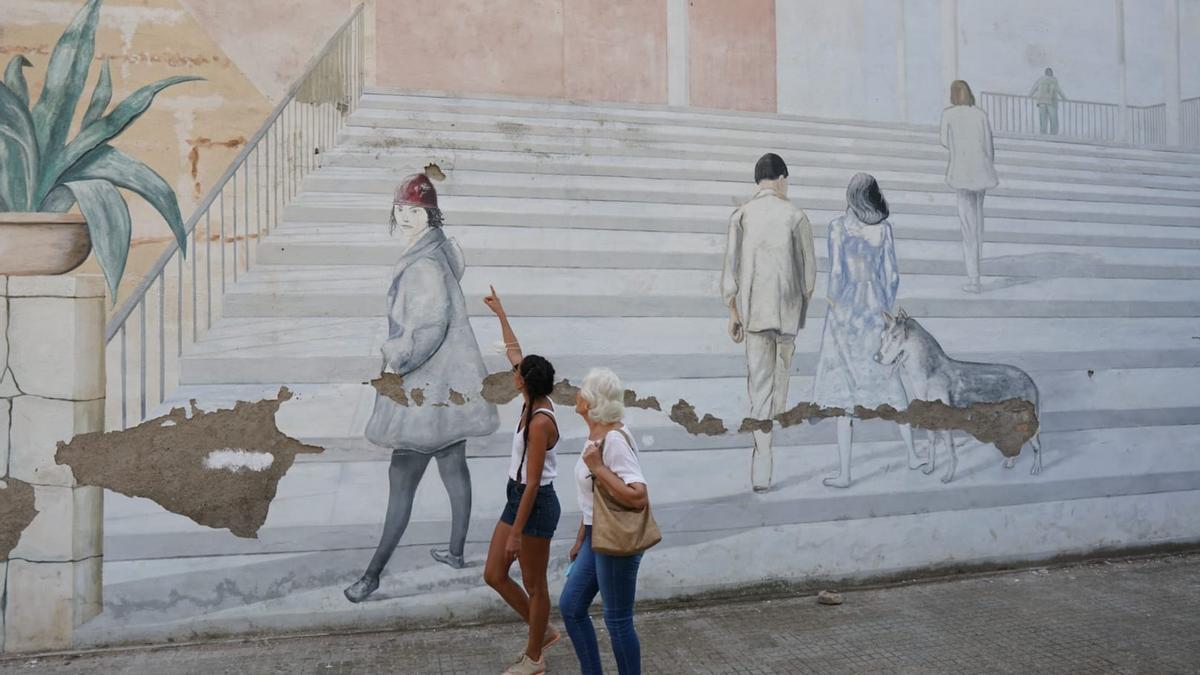 Dos mujeres pasan por delante del mural de José Duarte en el Jardín de los Poetas.