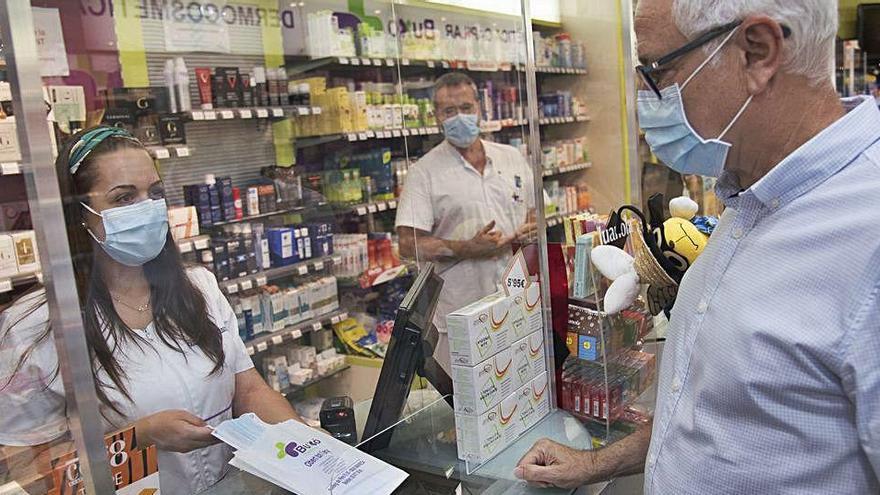 Una professional de la farmàcia Buxó de Manresa dispensa una mascareta quirúrgica durant una jornada amb força vendes d&#039;aquest producte