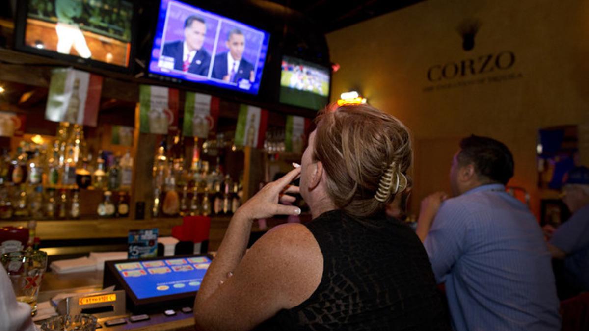 Dos ciudadanos siguen el debate entre Barack Obama y Mitt Romney, anoche, en un bar de Las Vegas.