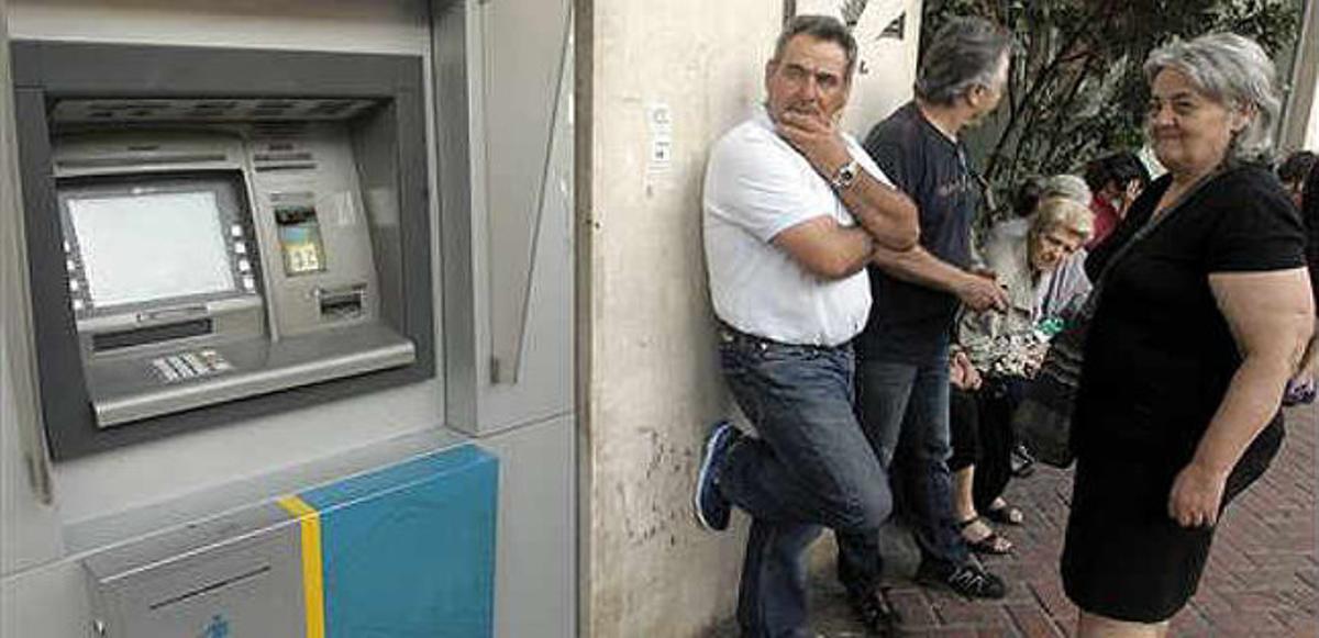 Ciudadanos griegos hacen cola ante una sucursal del Banco Nacional de Grecia hoy 29 de junio de 2015.