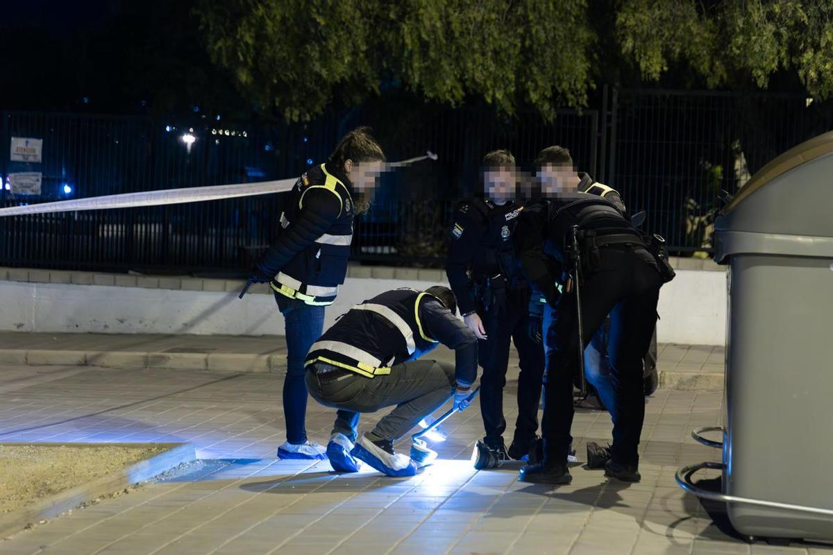 La Policía examina unas zapatillas halladas en un contenedor de basura cercano al lugar del hallazgo.