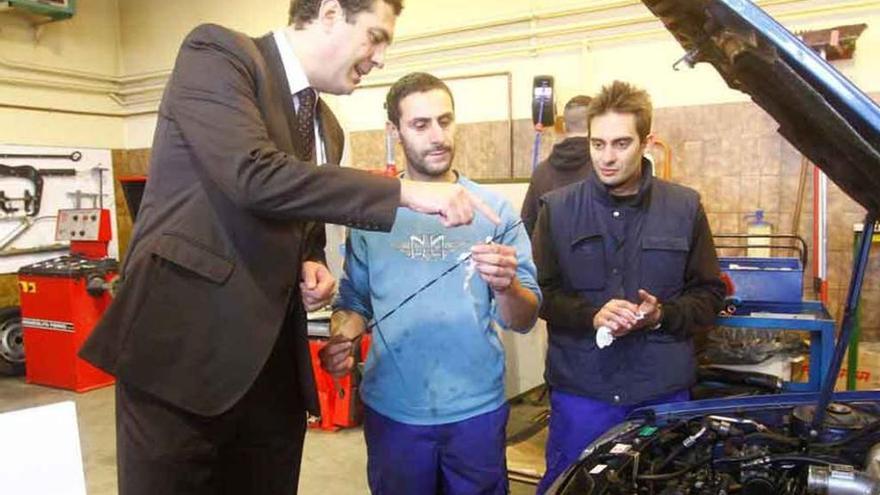 Amparo Sanz y Alberto Castro junto a dos alumnos del curso de mantenimiento de vehículos.