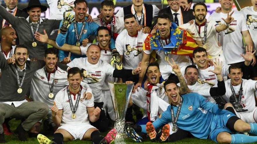 Los jugadores del Sevilla posan a la conclusión del partido con el trofeo. // Efe