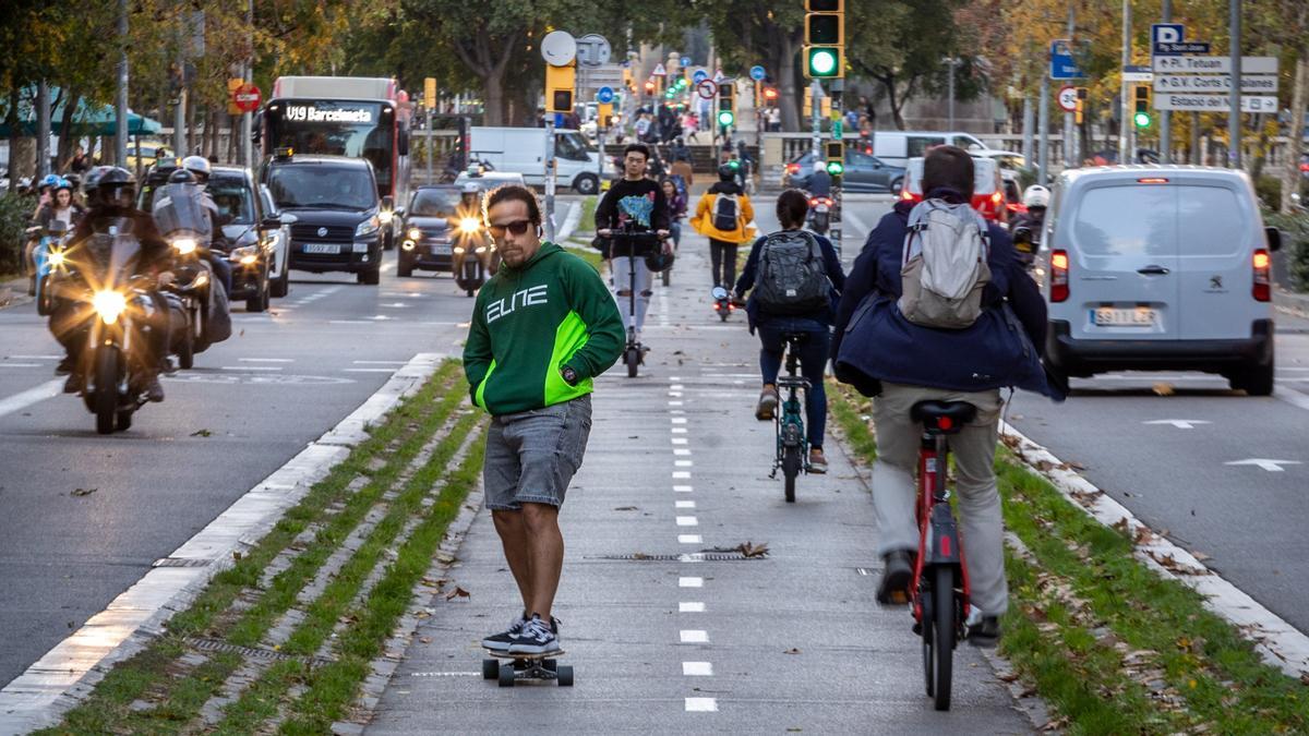 Patinetes, bicicletas, coches, motos y autobuses circulan por el paseo Sant Joan de Barcelona.