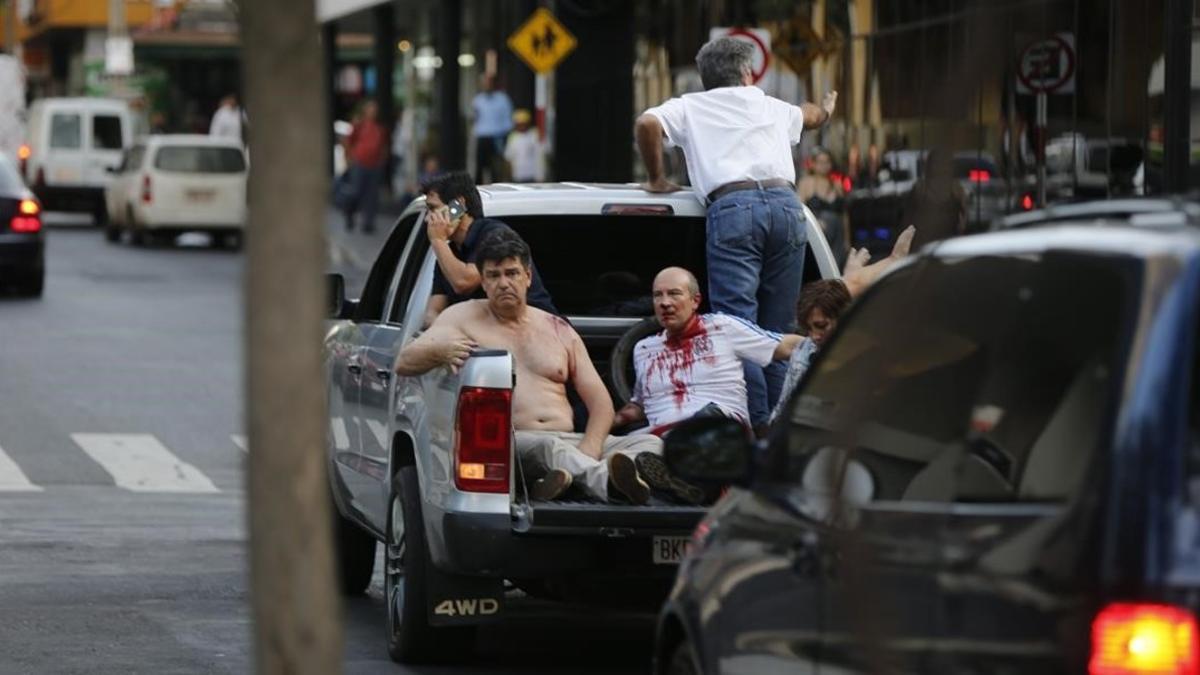 Efraín Alegre, líder del Partido Liberal (izquierda), junto a un herido en los disturbios de la madrugada del sábado.
