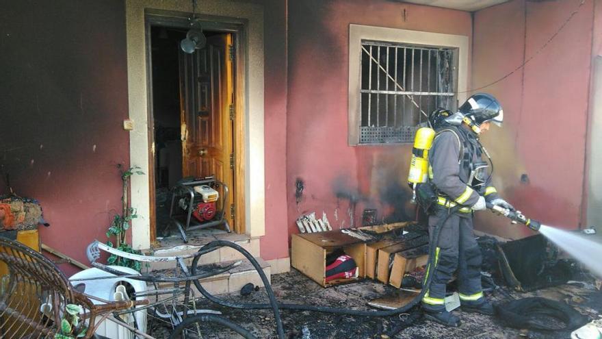 Un bombero sofoca las llamas en la vivienda.